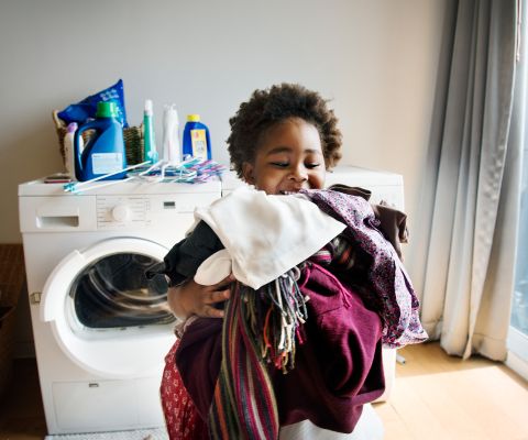 Kind trägt frische Wäsche herum
