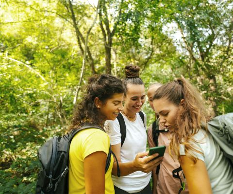 Un gruppo di giovani donne fa geocaching nella foresta