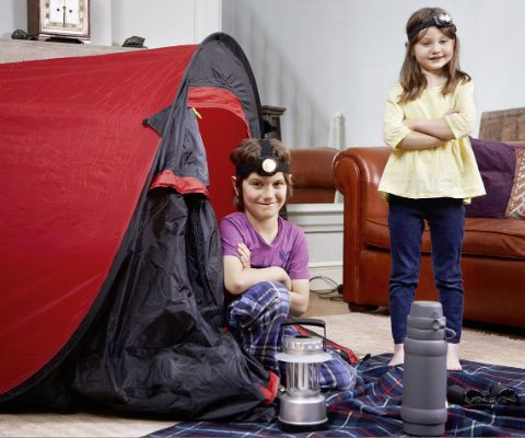 Zwei Mädchen haben ein Zelt im Wohnzimmer aufgestellt