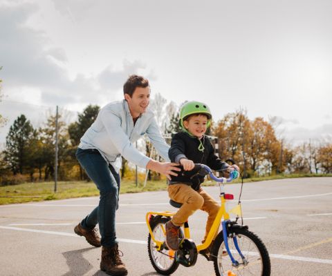 Un padre insegna al figlio ad andare in bicicletta