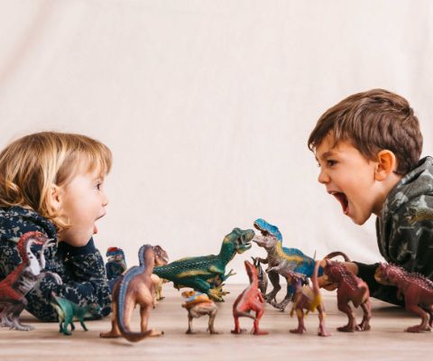 Bambini che giocano con i dinosauri