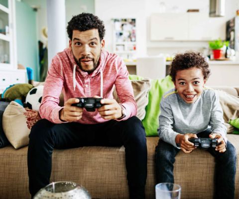 Console de jeux pour enfant: père et fils jouant ensemble à des jeux sur ordinateur