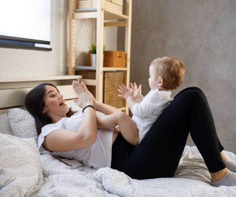 Una mamma gioca a battere le mani con il bebè
