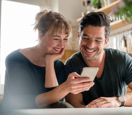 Mann und Frau organisieren ihren Familienalltag über das Smartphone 