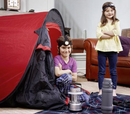 Deux jeunes filles ayant monté une tente dans la salle de séjour