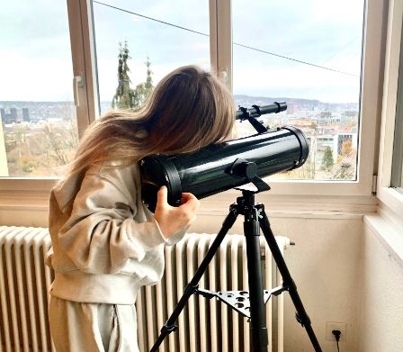 Une fillette regarde dans un télescope